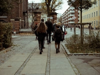 people walking on pathway near buildings during daytime