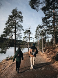 2 women standing on brown field near lake during daytime