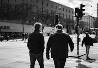 a couple of people walk across a crosswalk