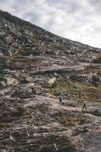a group of people hiking up a rocky hill