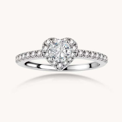 Heart-shaped halo ring with brilliant moissanite center stone surrounded by smaller crystals in sterling silver setting