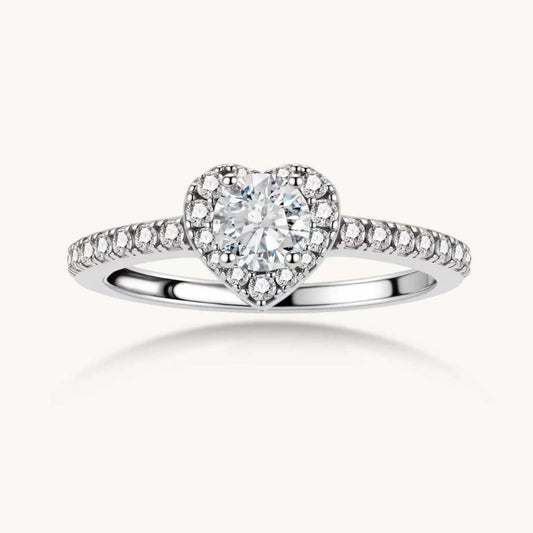 Heart-shaped halo ring with brilliant moissanite center stone surrounded by smaller crystals in sterling silver setting